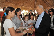 President Shimon Peres receives a Captain Compost Superhero t-shirt from the children of Kibbutz Lotan during his visit to the community's educational EcoPark.