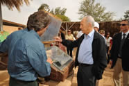 Kibbutz General Director Mark Naveh, a NETZER graduate from Australia, boils water for tea with President Shimon Peres in one of Kibbutz Lotan's solar ovens – an environmentally friendly way to save electricity.